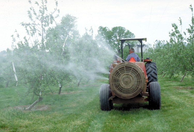 Spraying an apple orchard with an air-blast sprayer. (Photo: John Hartman, UK)